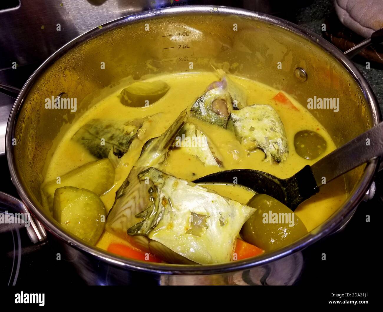 Würziges gelbes Curry mit spanischer Makrele und Tomaten Stockfoto
