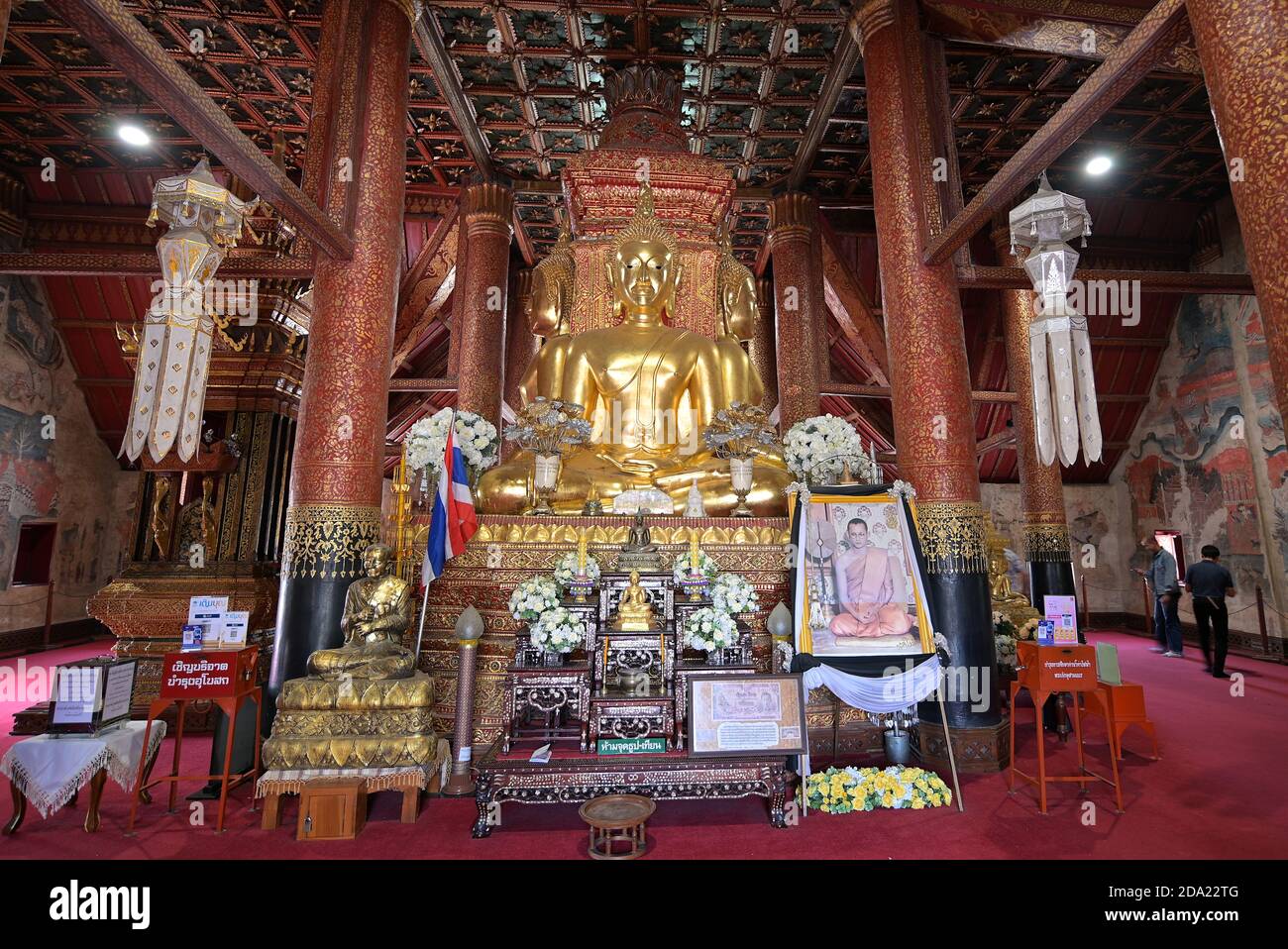 Blick auf die nach Norden gerichtete Buddha-Statue im Wat Phumin, Nans berühmtem buddhistischen Tempel, mit Bildern des thailändischen Mönchs Somdet Toh (links) und König Rama IX (rechts) Stockfoto