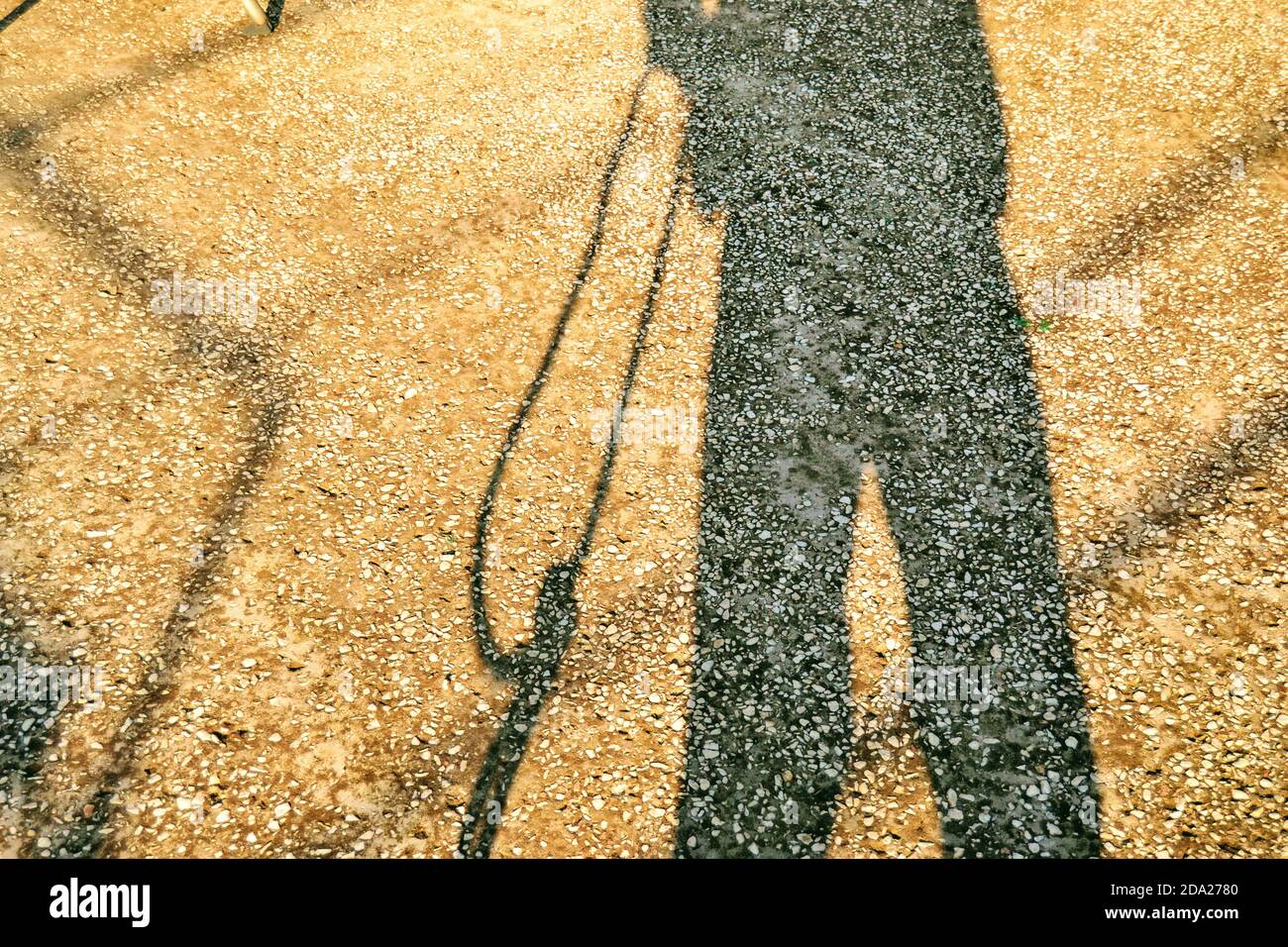 Schatten und Silhouette ein Mann auf Betonboden. Der Mensch hält ein Seil in der Silhouette. Stockfoto