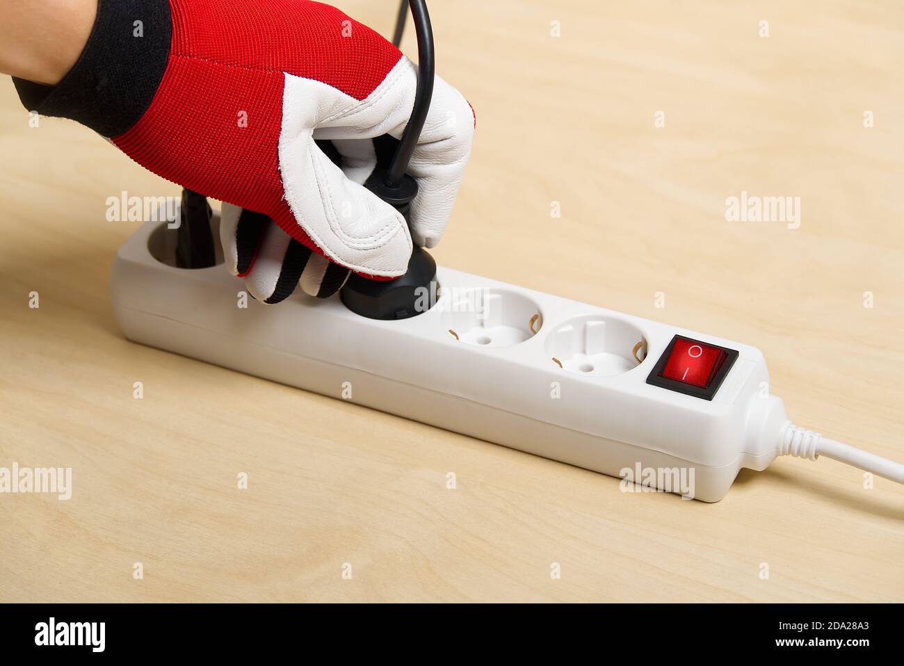 Nahaufnahme eines Elektrikers, der Verlängerungskabel miteinander einsteckt. Mans Hand Stecker Verlängerungskabel Stockfoto