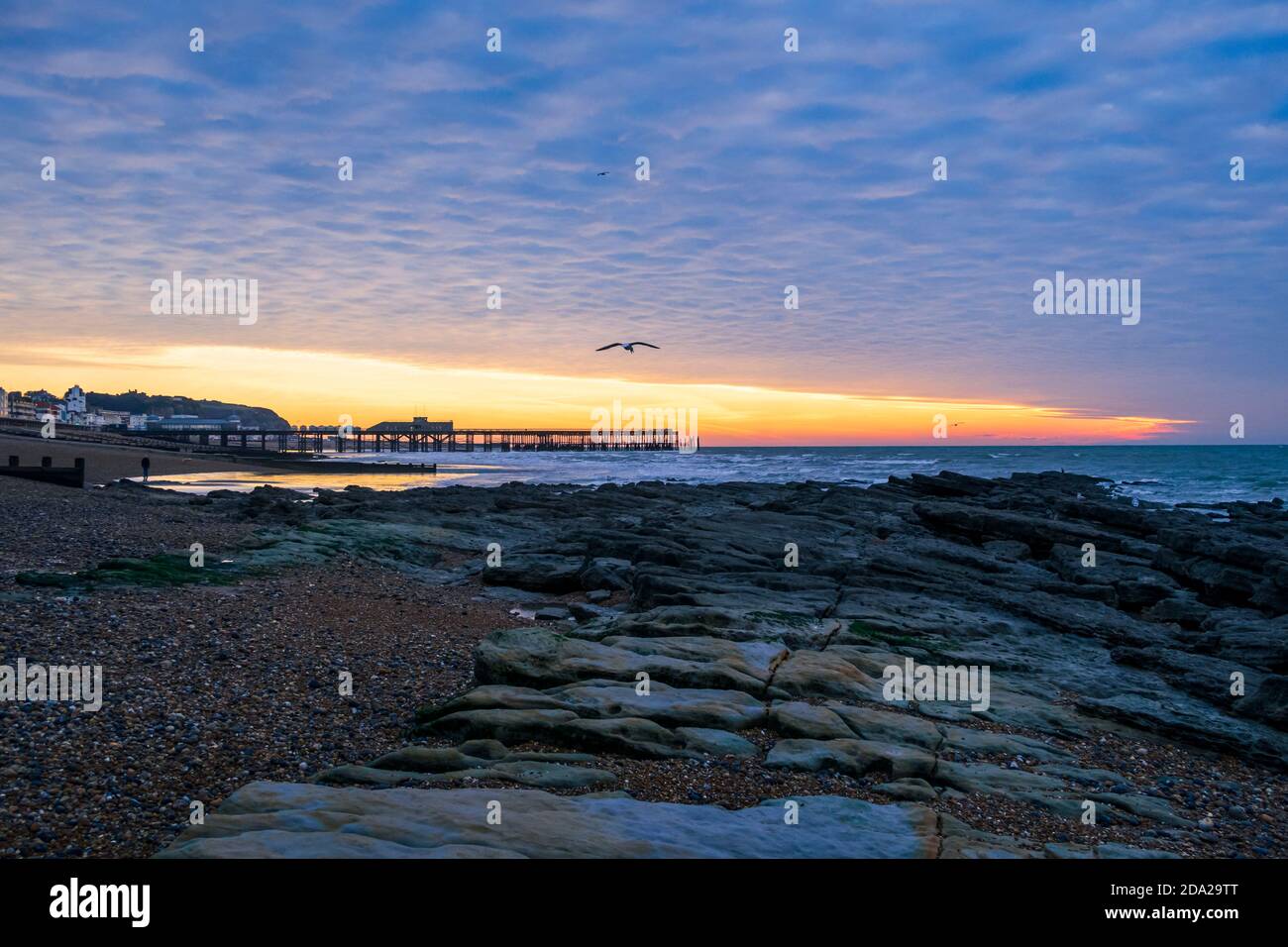 Dramatischer Makrelenhimmel im Morgengrauen über dem Hastings Pier in East Sussex südostengland Stockfoto