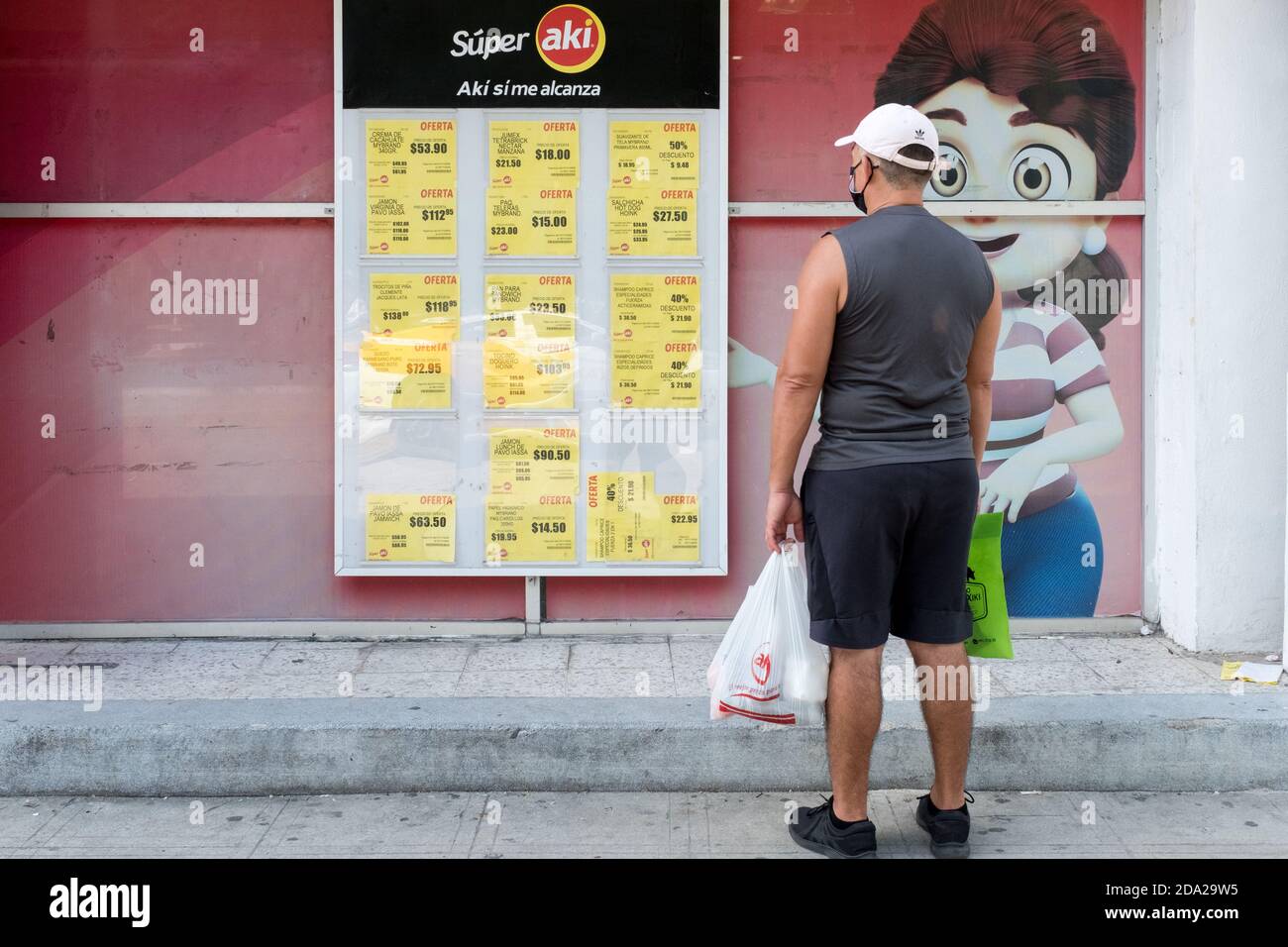 Mann, der sich die Preise des Supermarktes in Merida Mexiko anschaut Eine Wirtschaftskrise hat die covid-19 Pandemie ausgelöst Stockfoto