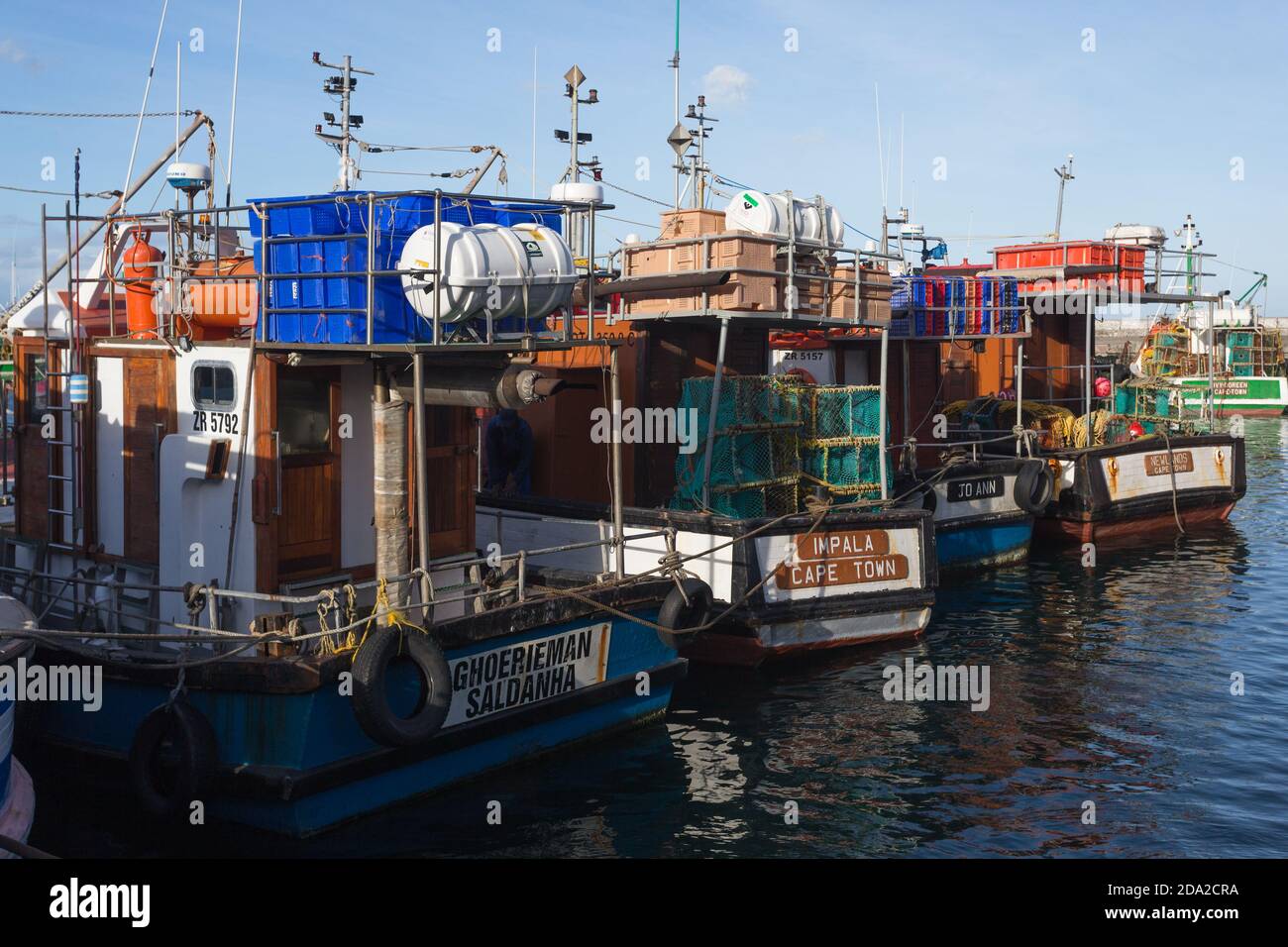 Fischerboote oder Schiffe in einer Reihe oder Reihe in Kalk Bay Hafen, Kapstadt, Südafrika Konzept kommerzielle Fischerei in Afrika Stockfoto