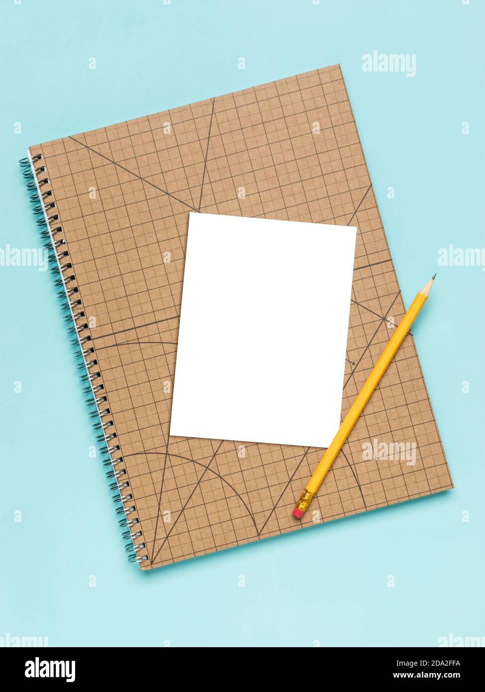 Weiße Karte auf quadratischen Notizbuch mit Bleistiftmockup. Leerer Bereich maskiert mit Beschneidungspfad, Türkisfarbener Hintergrund, Hochwinkelansicht. Stockfoto