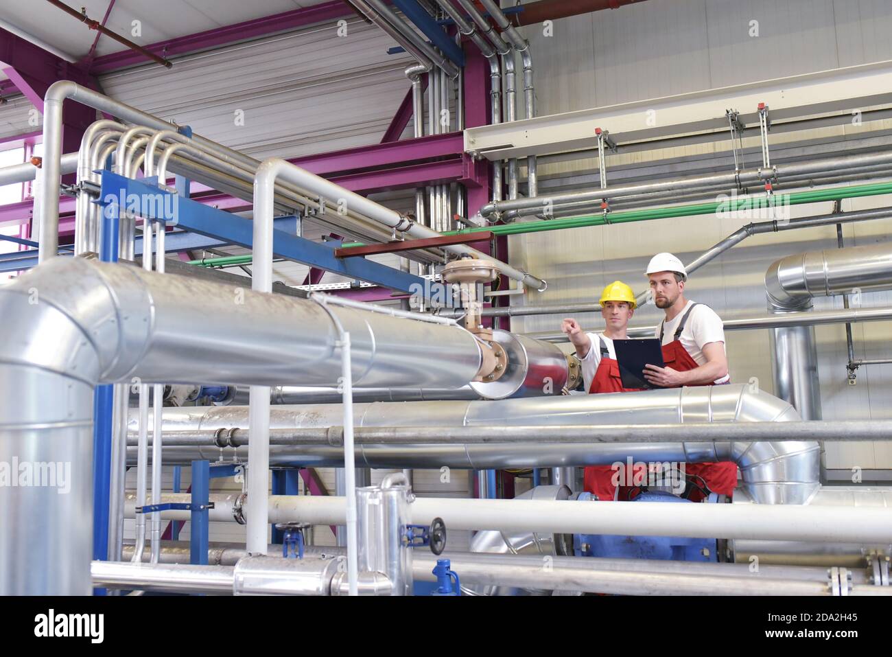 Mechanik reparieren einer Maschine in einem modernen Industriebetrieb - Beruf und Teamarbeit Stockfoto