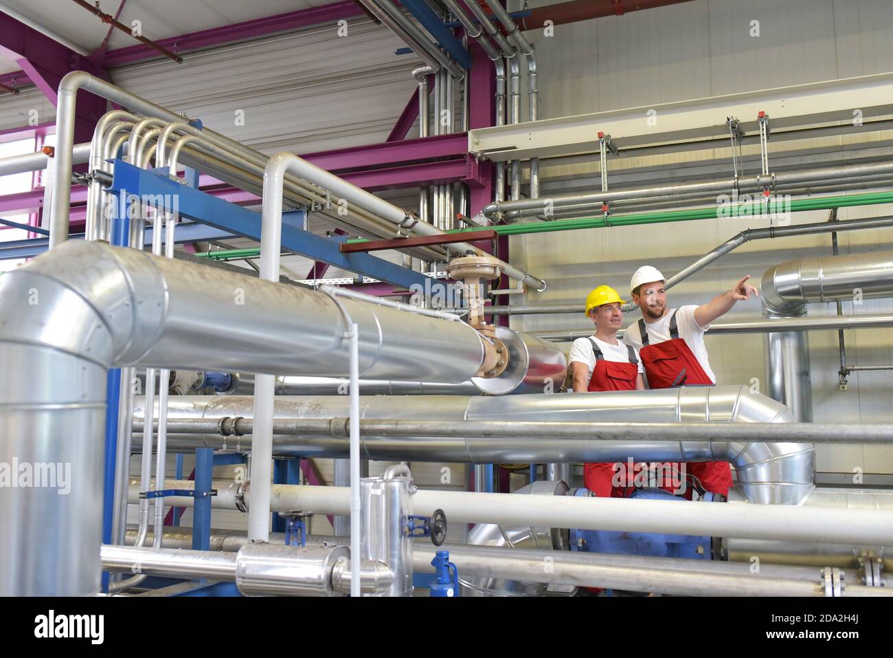 Mechanik reparieren einer Maschine in einem modernen Industriebetrieb - Beruf und Teamarbeit Stockfoto