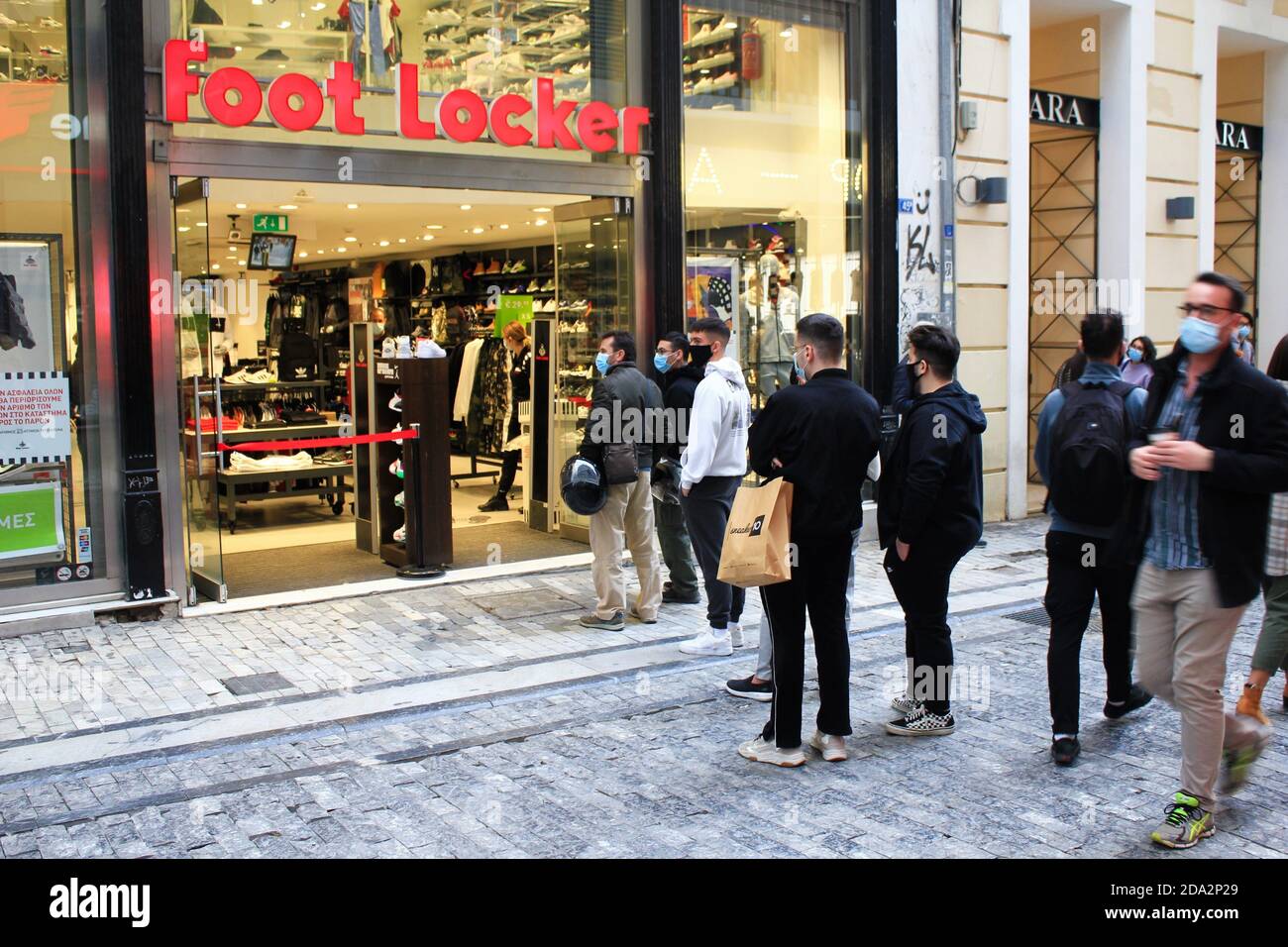 Die Kunden stehen Schlange, um in die Bekleidungsgeschäfte in der Mitte zu gelangen Von Athen nach der Ankündigung für eine zweite Sperre in Griechenland vom 7. Bis 30. Novembe Stockfoto