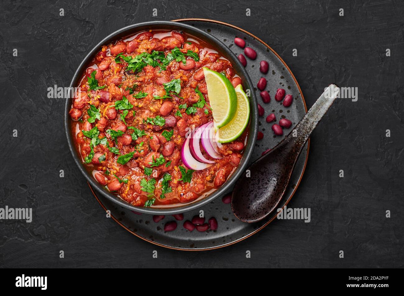 Rajma Masala Curry in schwarzer Schale auf dunkler Schieferplatte. Red Niere Bean Dal ist indische Küche vegetarisches Gericht. Asiatische Küche, Essen. Draufsicht Stockfoto