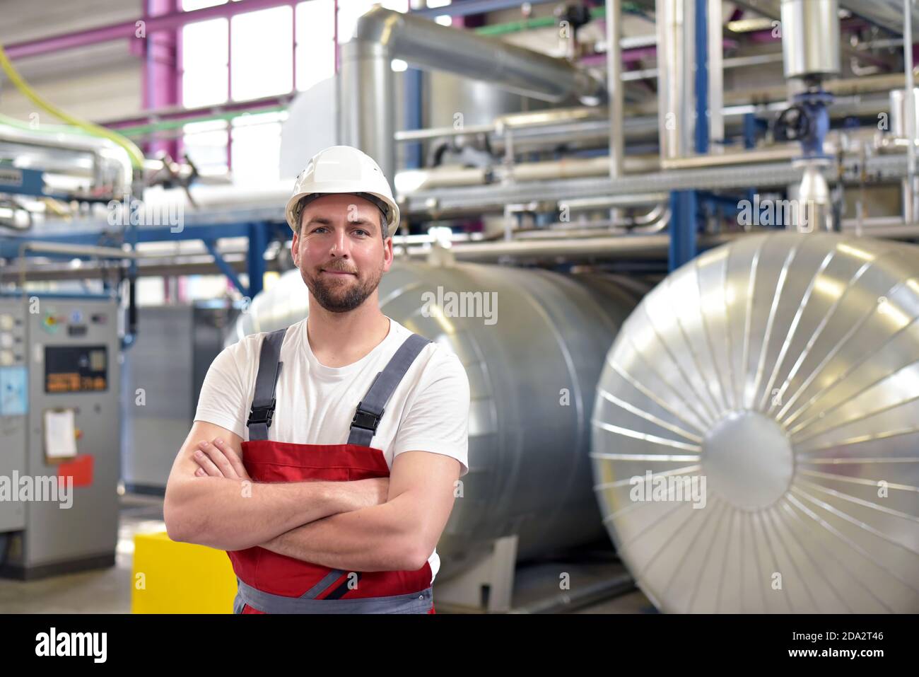 Portrait von erfolgreichen lächelnden Arbeitnehmer/Ingenieure vor Ort in einem industriellen Fabrik mit Helm Stockfoto
