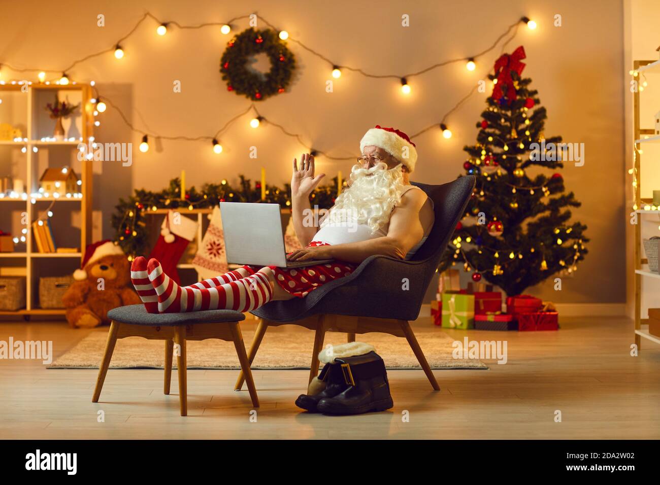 Senior Santa in lustigen Hause festliche Kostüm chatten online mit Familie Stockfoto