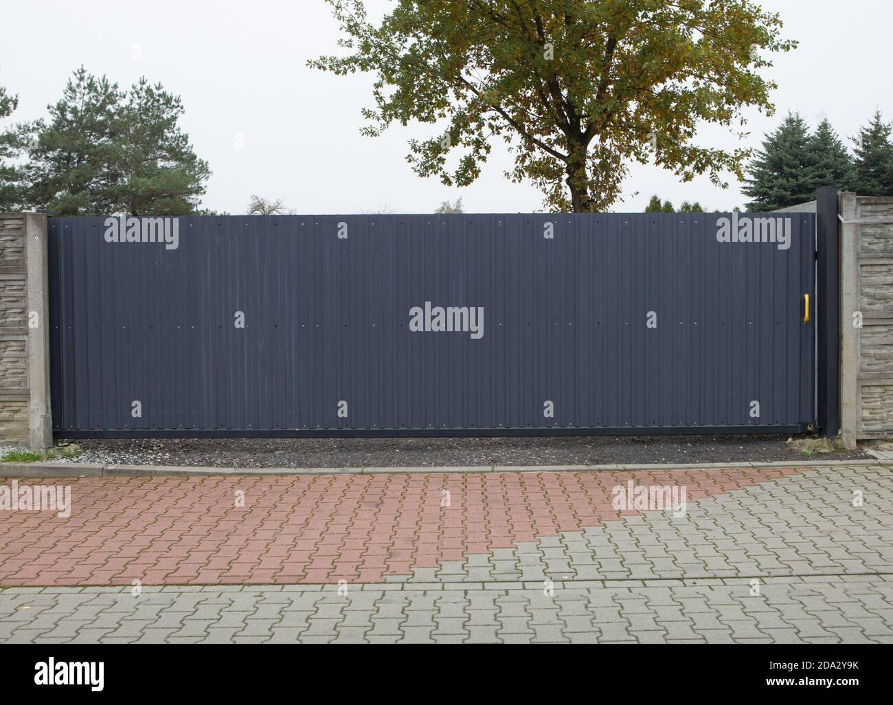 Automatisches graues Schiebetor - klassisches Metalltor. Geschlossenes Schiebetor in grau, Eingang zum Grundstück. Stockfoto