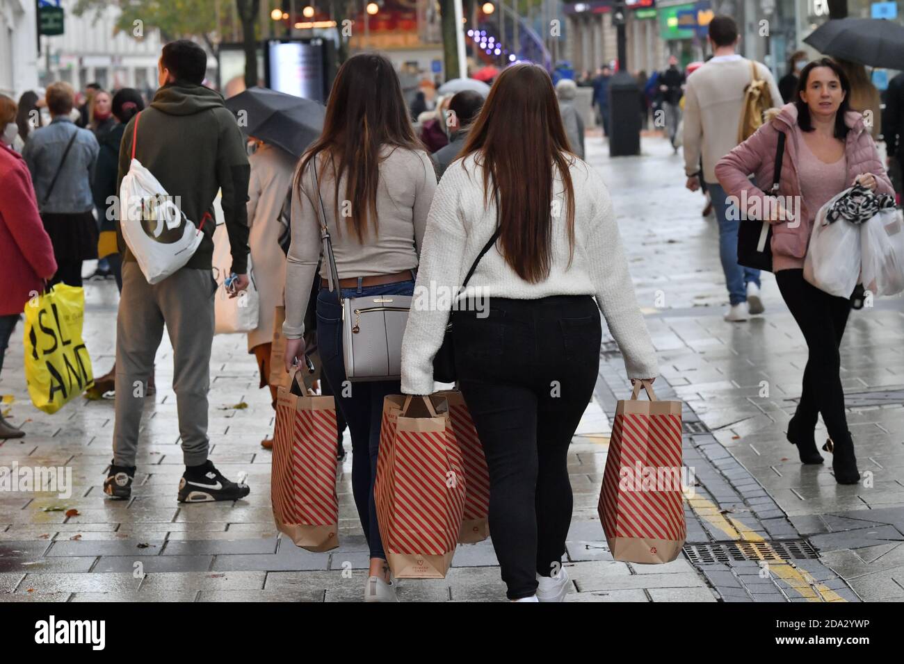 Menschen mit Primark-Einkaufstaschen in Cardiff, da sich die Einschränkungen nach einer zweiwöchigen „Feuerpause“-Sperre in Wales lockern. Stockfoto