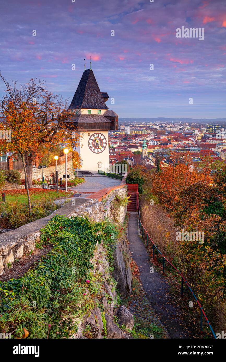 Graz, Österreich. Stadtbild von Graz, Österreich mit dem Uhrenturm bei schönem Herbstuntergang. Stockfoto