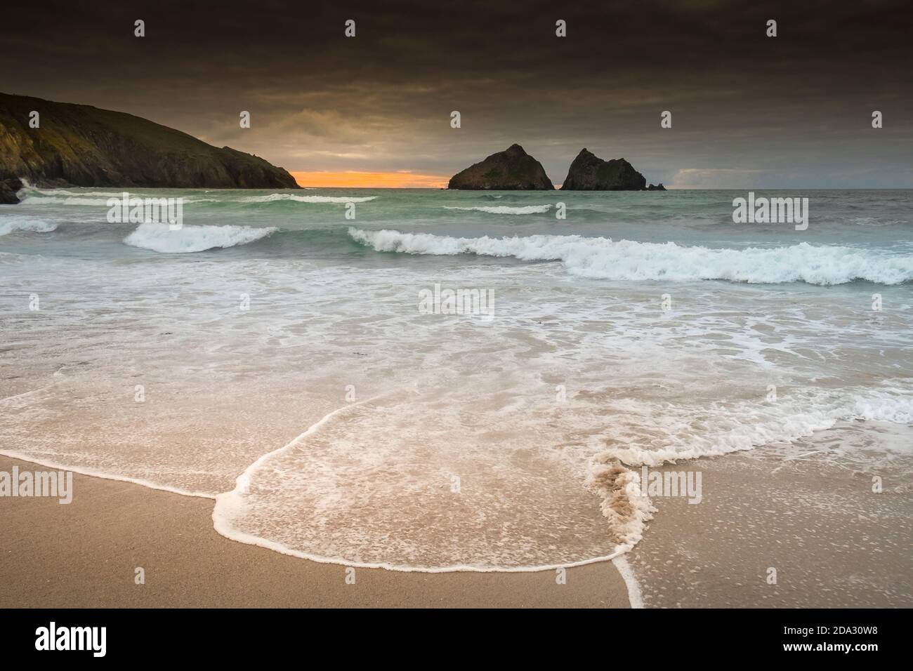 Abendlicht über Gull Rocks, wenn die Flut kommt in Holywell Bay in Cornwall. Stockfoto
