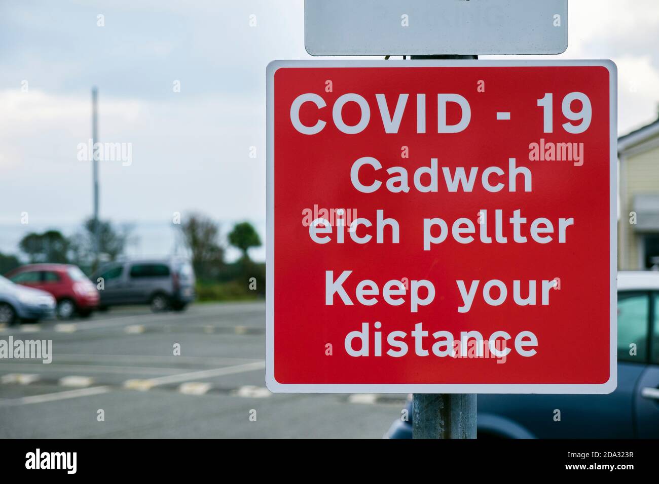 Coronavirus Pandemie Covid-19 zweisprachige Schilderwarnung Halten Sie Abstand in Englisch und Cadwch eich Pellter in Walisisch. Anglesey North Wales Großbritannien Stockfoto