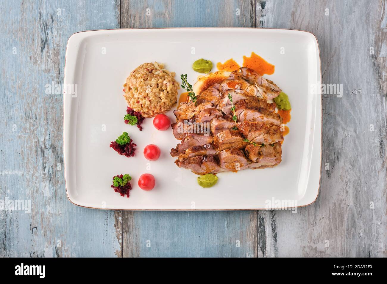 Gegrilltes Steak mit Sauce und Bulgur Pilaf auf Holztisch. Stockfoto