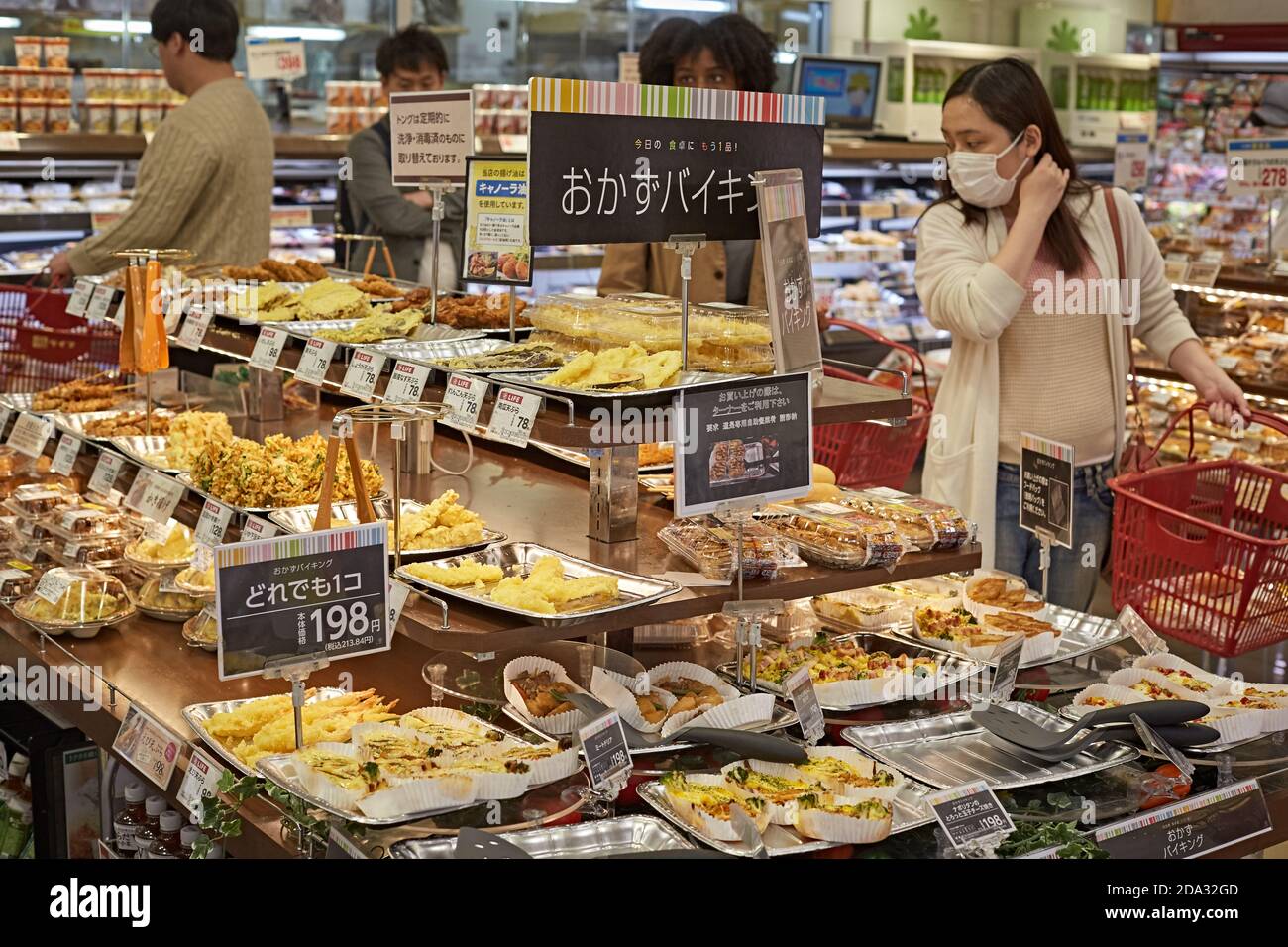 Osaka, Japan, April 2018. Eine Frau, die Lebensmittel zum Mitnehmen in einem städtischen Supermarkt kauft. Stockfoto