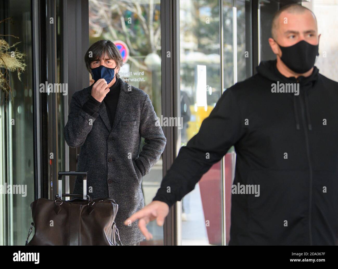 Leipzig, Deutschland. November 2020. Fußball: Nationalmannschaft, vor dem internationalen Spiel gegen die Tschechische Republik. Bundestrainer Joachim Löw steht bei seiner Ankunft im Hotel an der Tür und stellt seinen Mund- und Nasenschutz ein. Quelle: Robert Michael/dpa-Zentralbild/dpa/Alamy Live News Stockfoto
