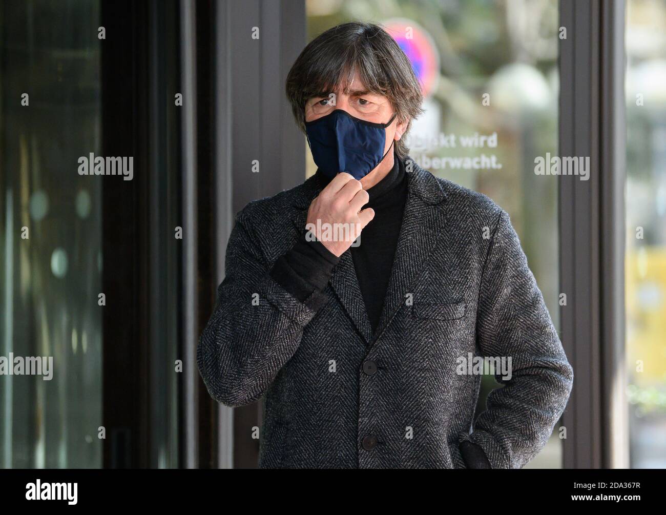 Leipzig, Deutschland. November 2020. Fußball: Nationalmannschaft, vor dem internationalen Spiel gegen die Tschechische Republik. Bundestrainer Joachim Löw steht bei seiner Ankunft im Hotel an der Tür und stellt seinen Mund- und Nasenschutz ein. Quelle: Robert Michael/dpa-Zentralbild/dpa/Alamy Live News Stockfoto