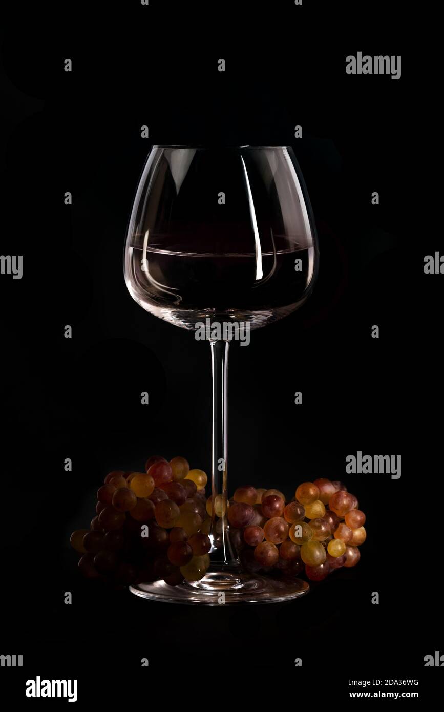 Setting mit frischer Traube und Wein in Glas schwarz baclground Stockfoto