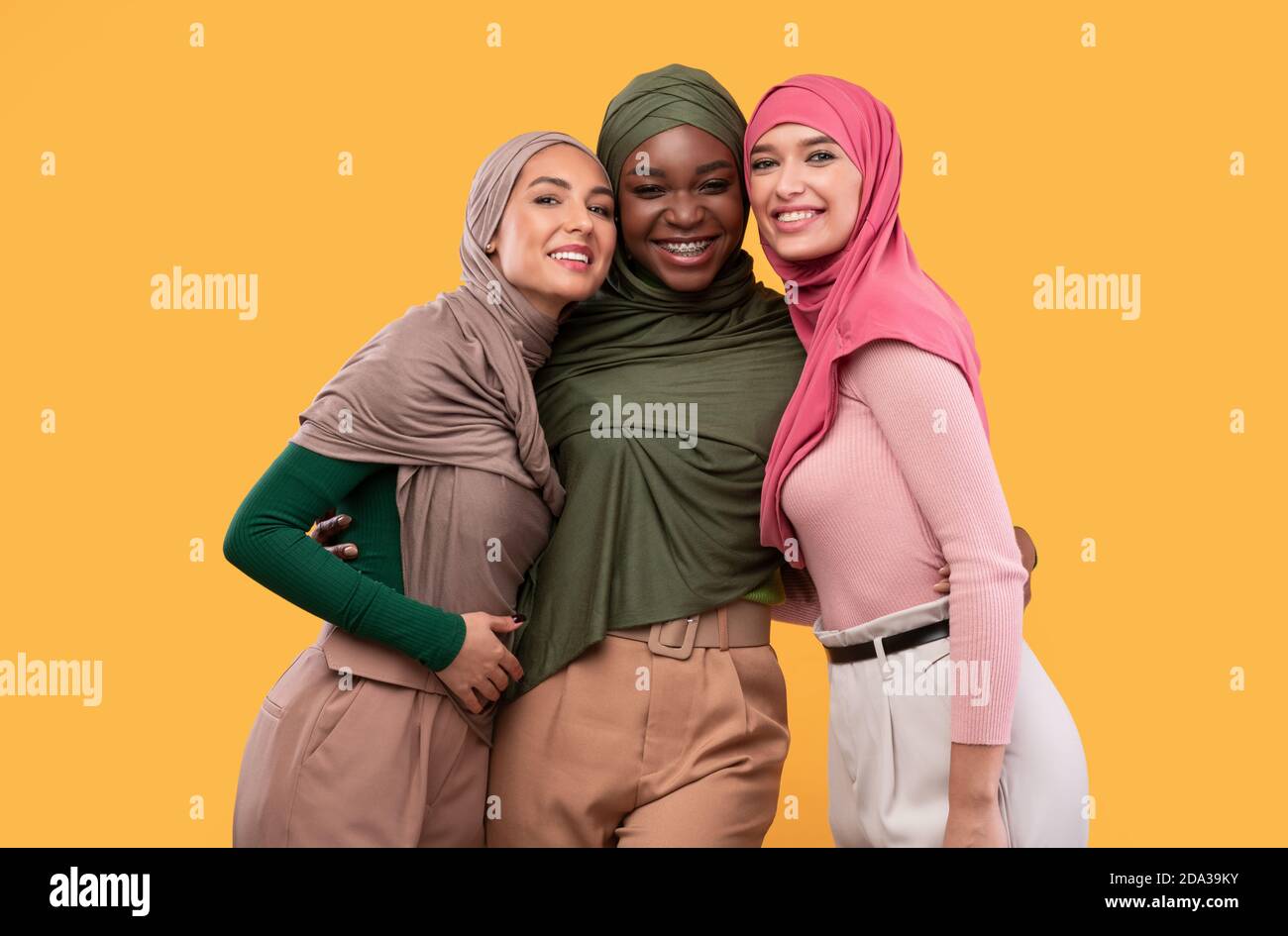 Drei Schöne Islamische Frauen In Hijab Posiert Auf Gelbem Hintergrund Stockfoto