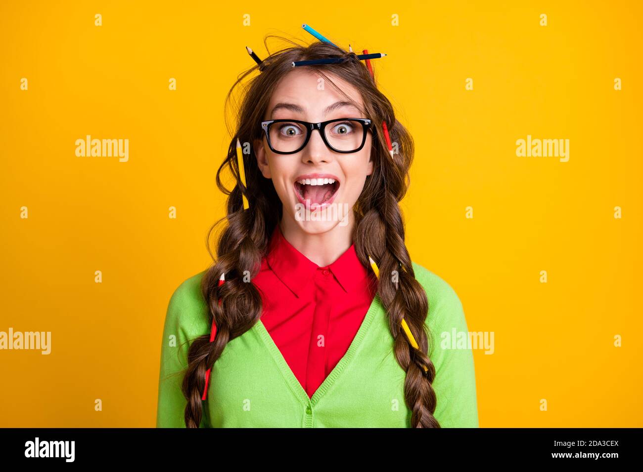 Foto von Nerd Teenager Mädchen mit Bleistift chaotisch Frisur aufgeregt  Tragen Sie grüne Kleidung isoliert Glanz Farbe Hintergrund Stockfotografie  - Alamy