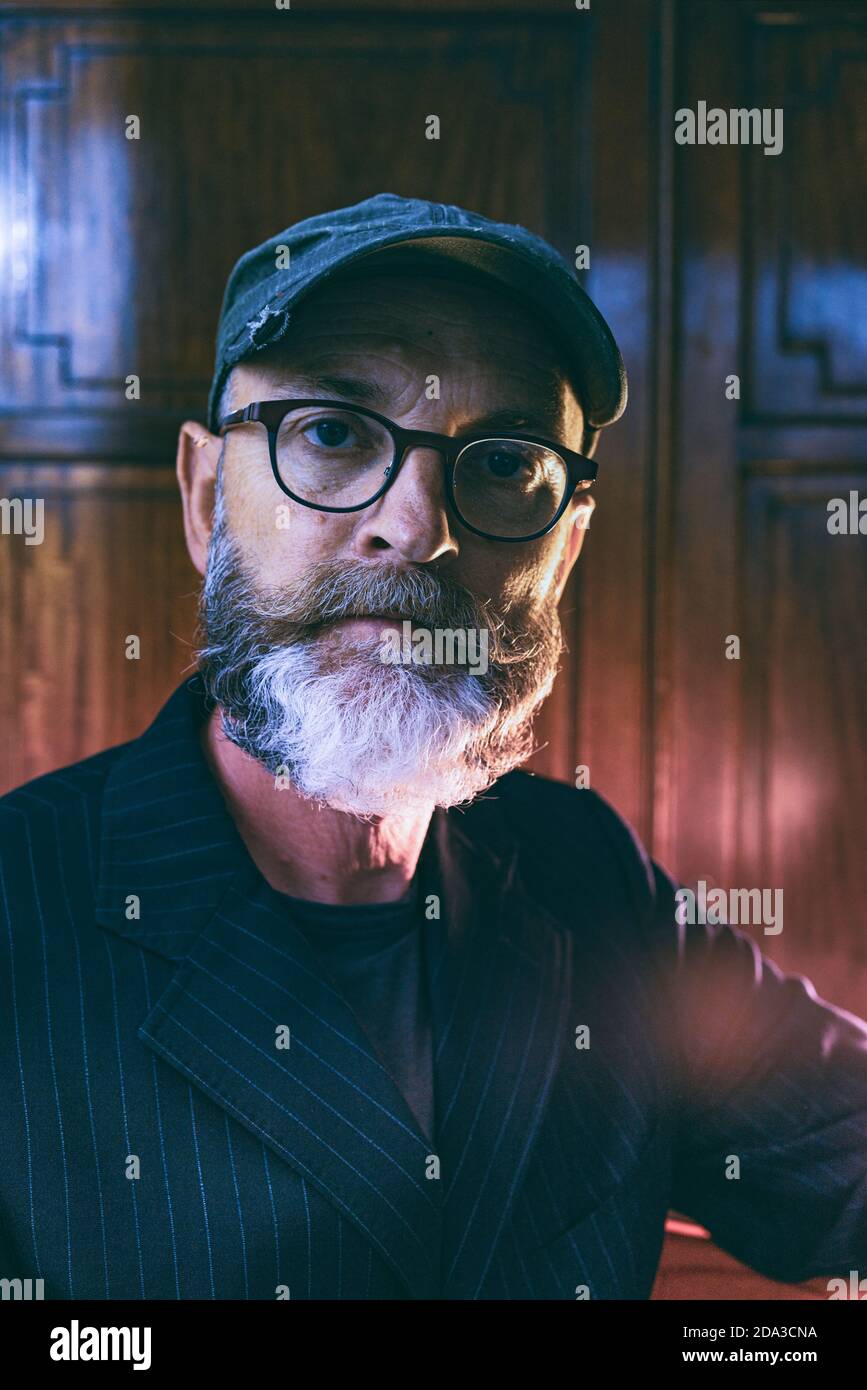 Nahaufnahme der Kopfaufnahme einer männlichen Figur mittleren Alters, die eine Brille trägt Blick auf die Kamera Stockfoto