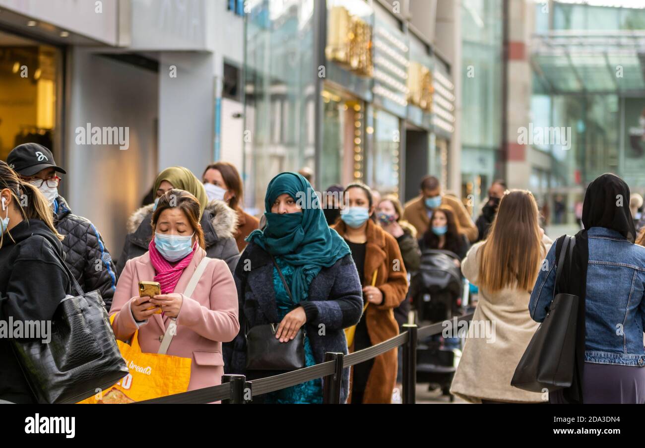 Einkäufer, die sich am letzten Tag vor der Sperrung in Birmingham, Großbritannien, für Primark anstellen Stockfoto