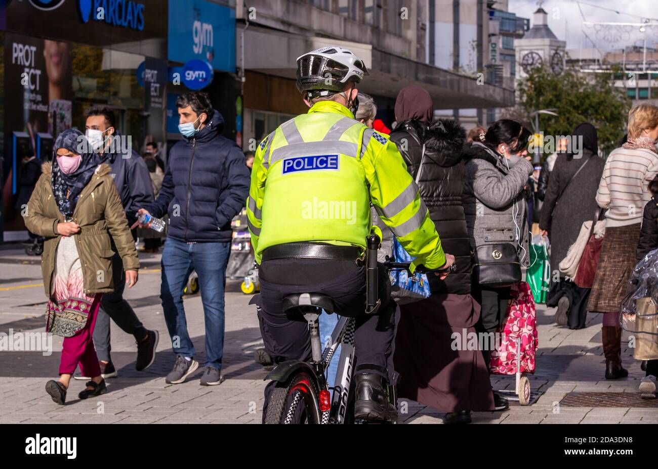 Polizist fährt Fahrrad durch Birmingham High Street Menschenmenge Stockfoto