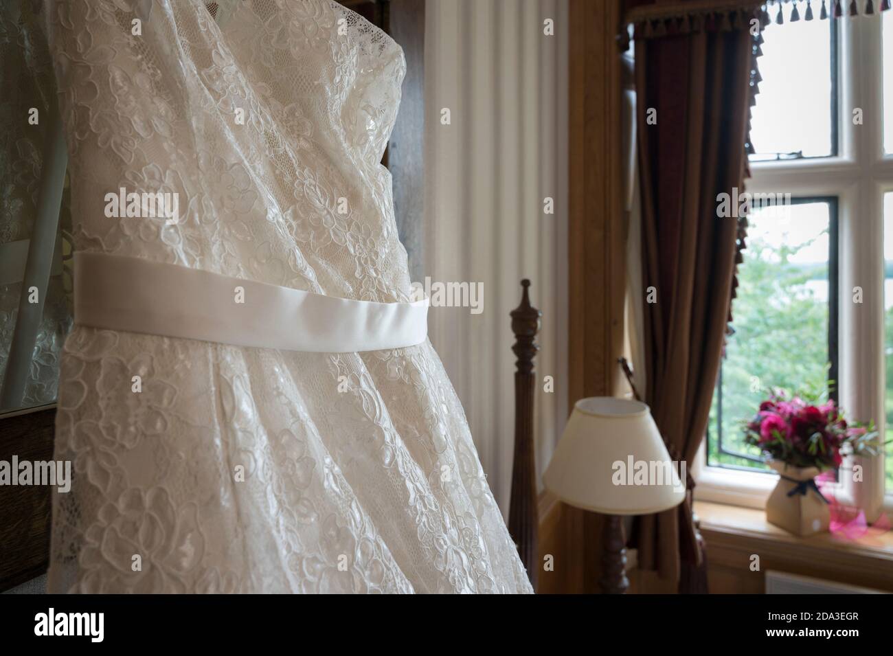Nahaufnahme der schönen weißen Hochzeitskleid hängen in einem Schlafzimmer vor der Hochzeit. Stockfoto