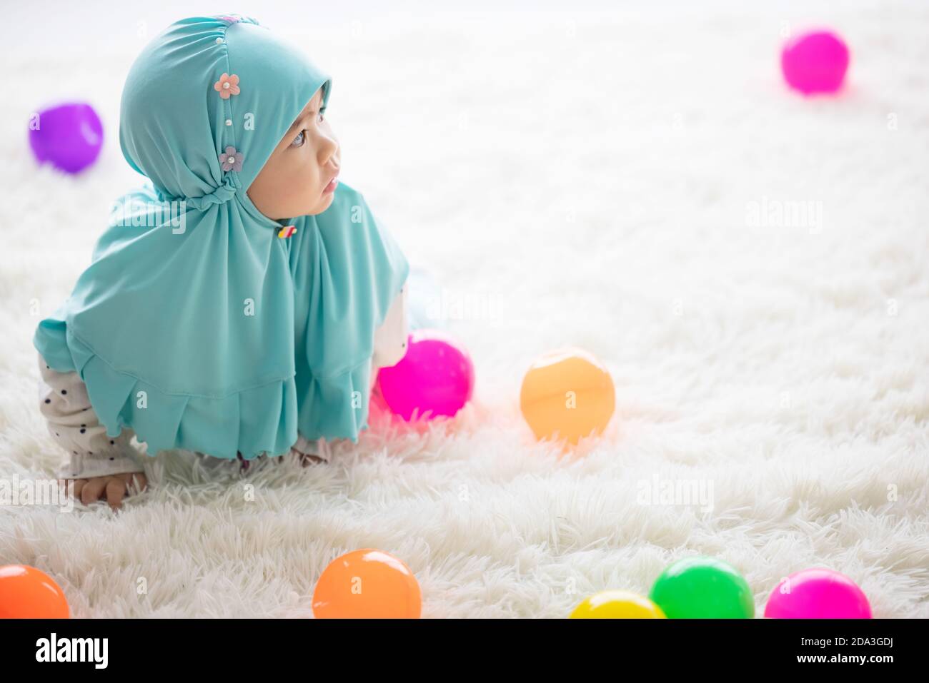 Muslim Baby spielt mit bunten Spielsachen im Wohnzimmer. Stockfoto