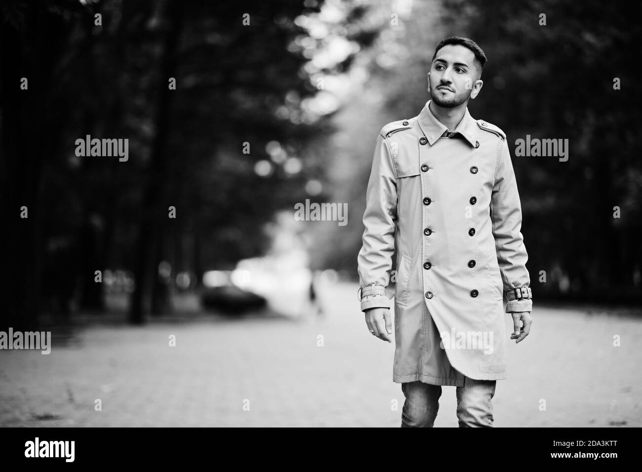 Stilvoller kuwaitischer Mann im Trenchcoat zu Fuß im Park. Stockfoto