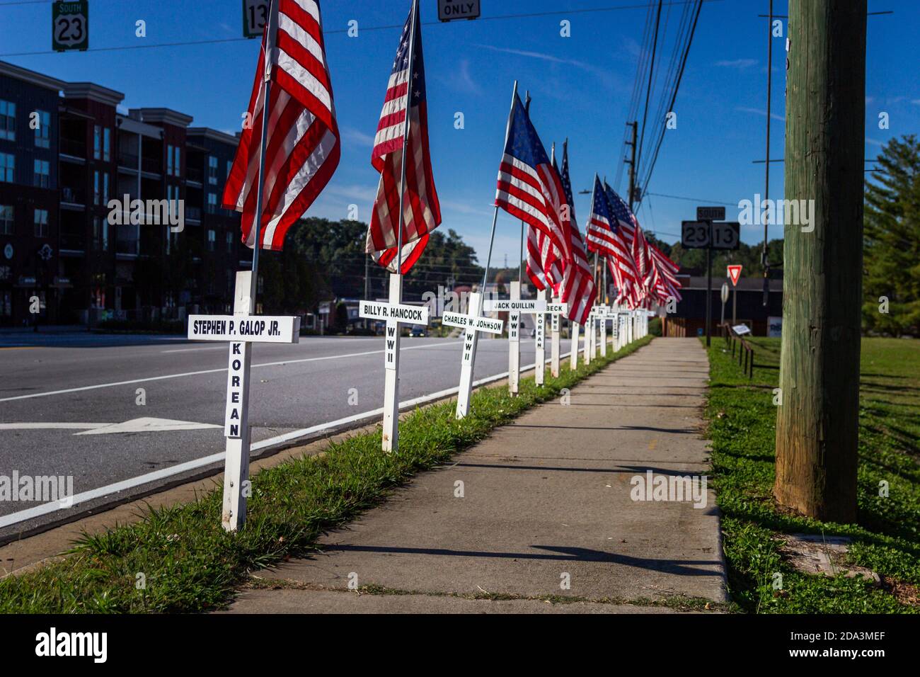 DULUTH, USA - 07. Nov 2020: Duluth, Georgia / USA - 6. November 2020: Weiße Kreuze und amerikanische Flaggen säumen eine Stadtstraße in Erinnerung Stockfoto