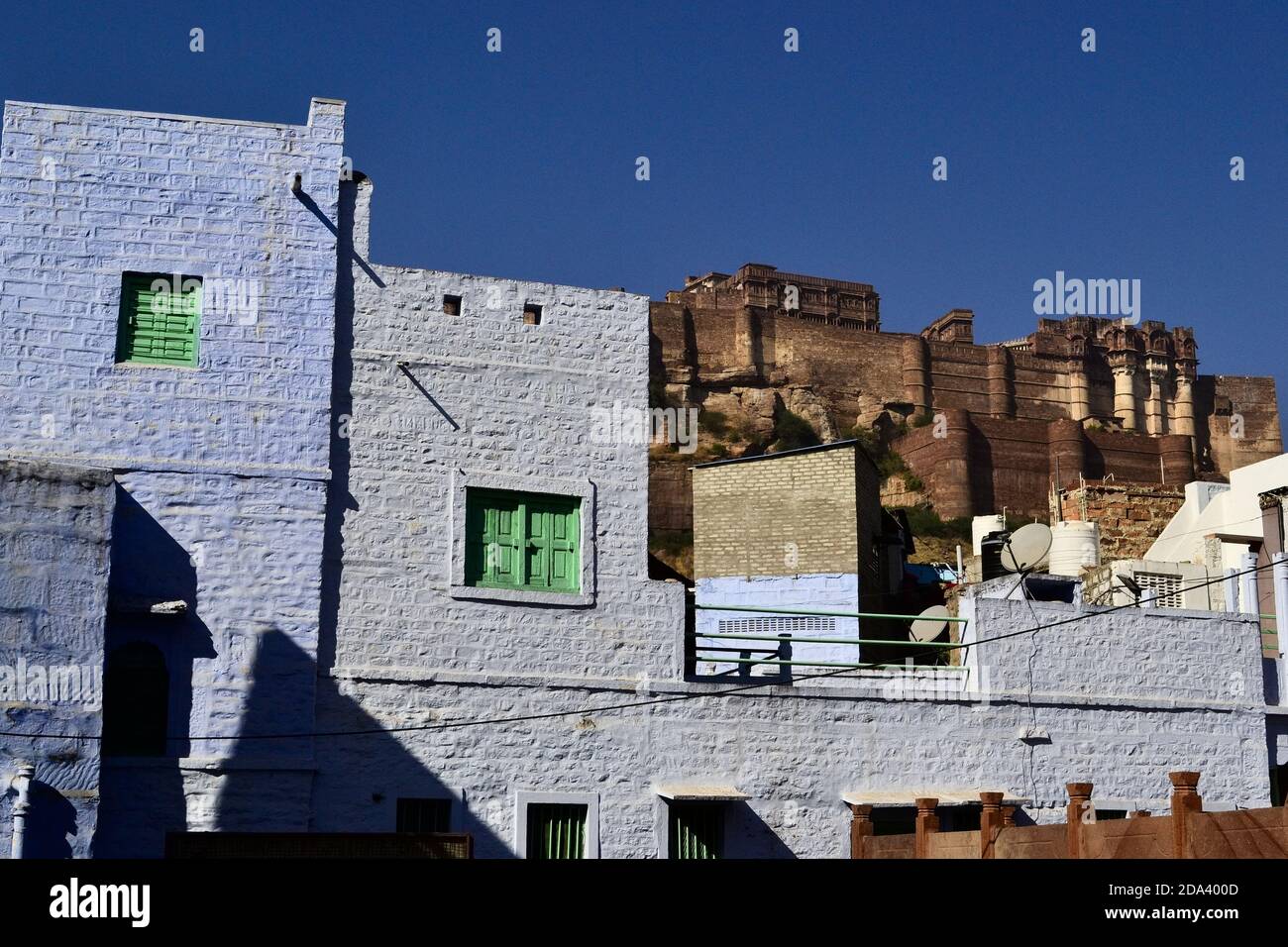 Blick auf Mehrangarh (Mehran Fort) von der alten Blauen Stadt. Ziegelmauer des alten Hauses auf einem Vordergrund. Jodhpur, Rajasthan, Indien Stockfoto