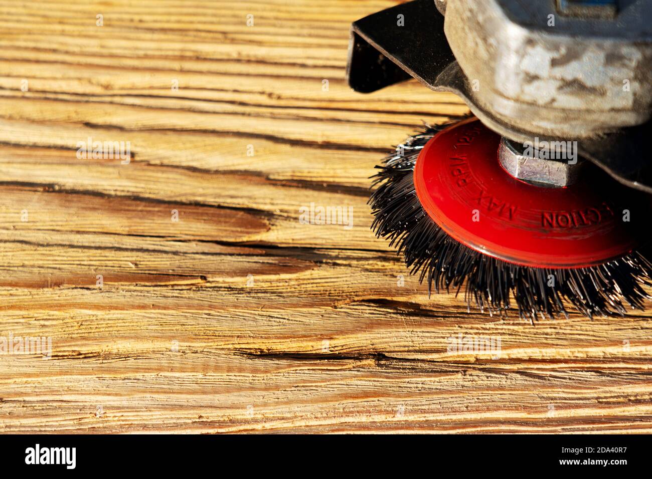 Elektrische rotierende Bürste Metallscheibe ein Stück Holz Schleifen  Stockfotografie - Alamy