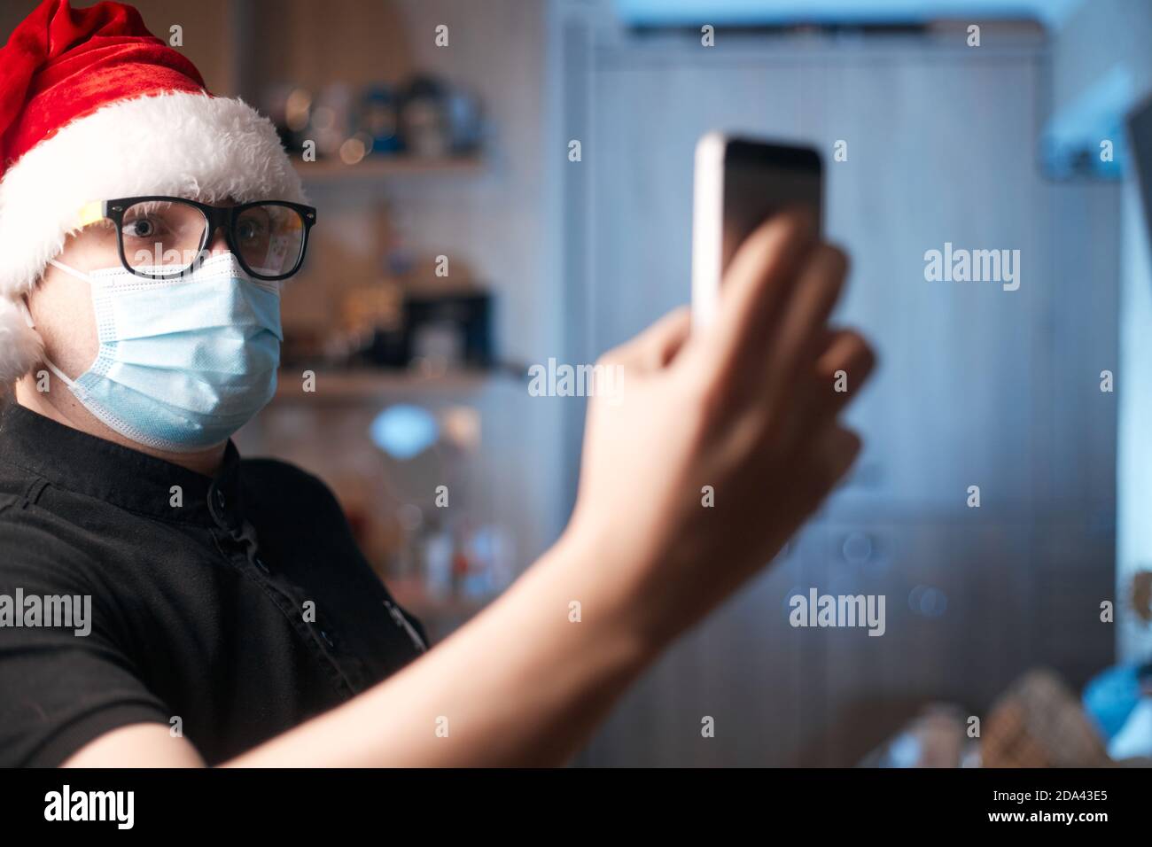 Weihnachtskonzept, kaukasischer Mann trägt medizinische Maske und santa Hut Stockfoto