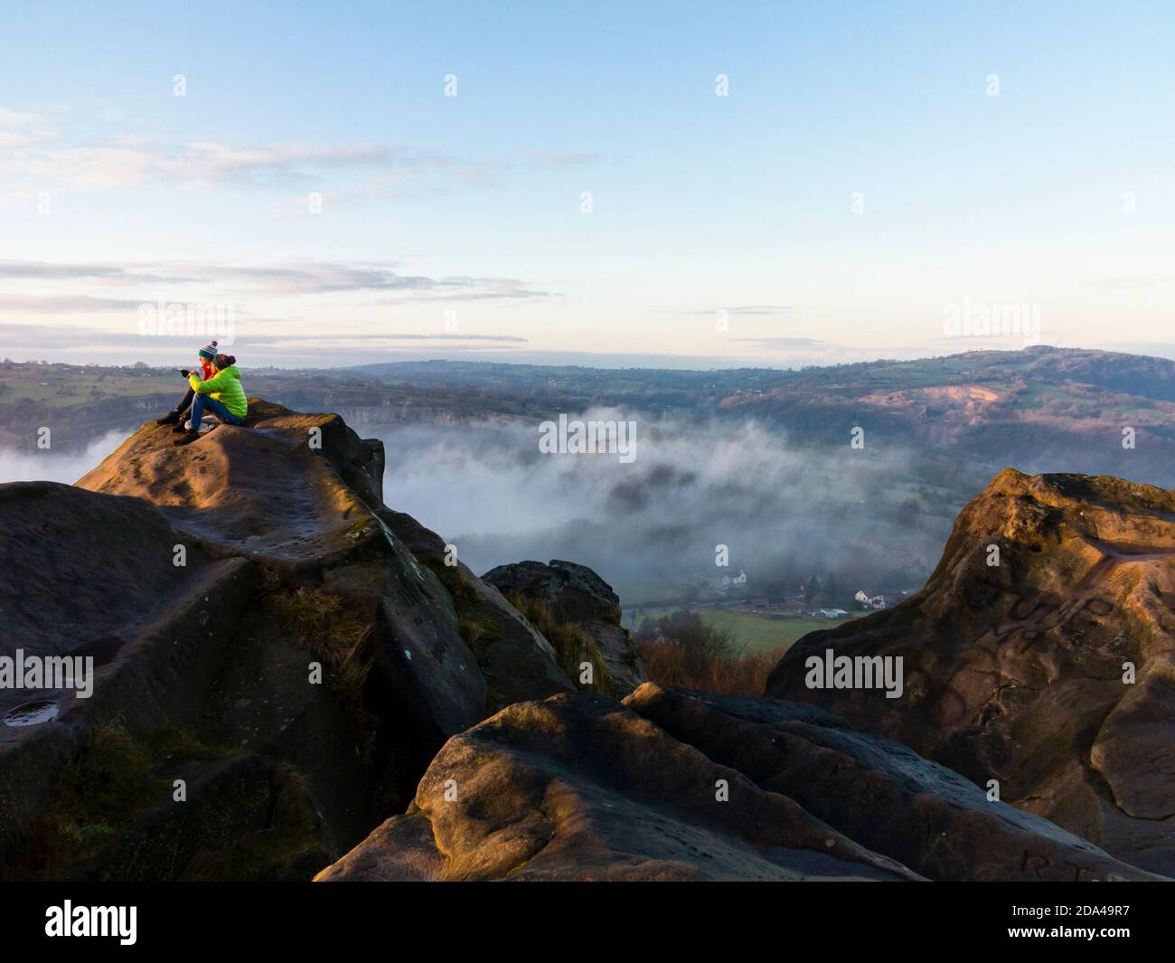 Paar in Winterlandschaft mit Nebel und Wolke Umkehrung an Black Rocks bei Cromford im Derbyshire Peak District England VEREINIGTES KÖNIGREICH Stockfoto