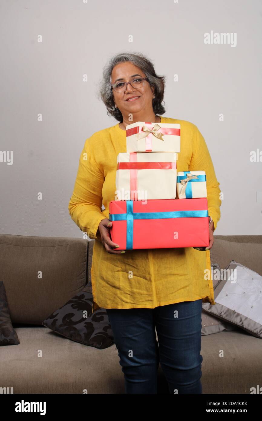Porträt einer glücklichen indischen Frau mit einem Stapel von Geschenken. Stockfoto