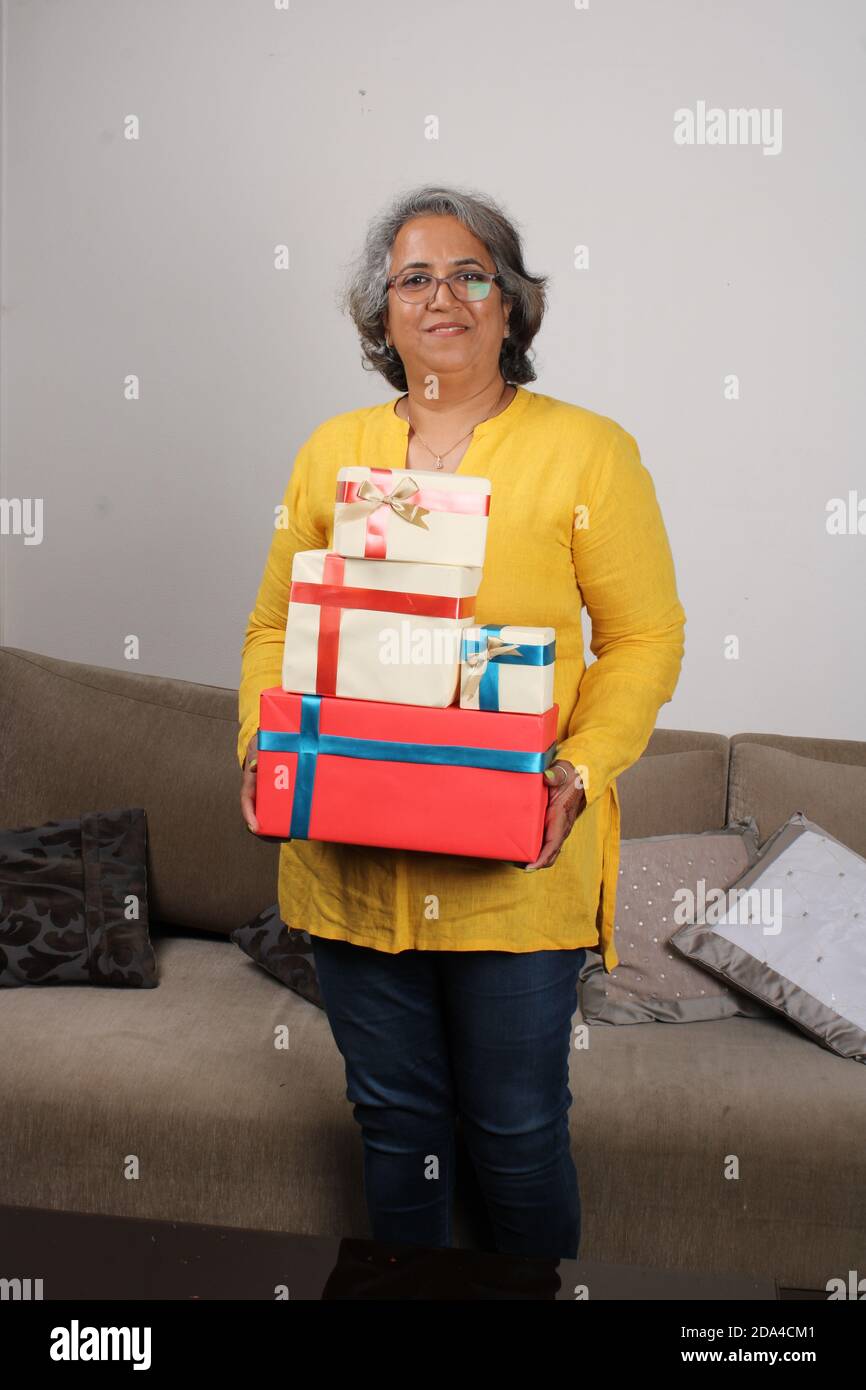 Porträt einer glücklichen indischen Frau mit einem Stapel von Geschenken. Stockfoto