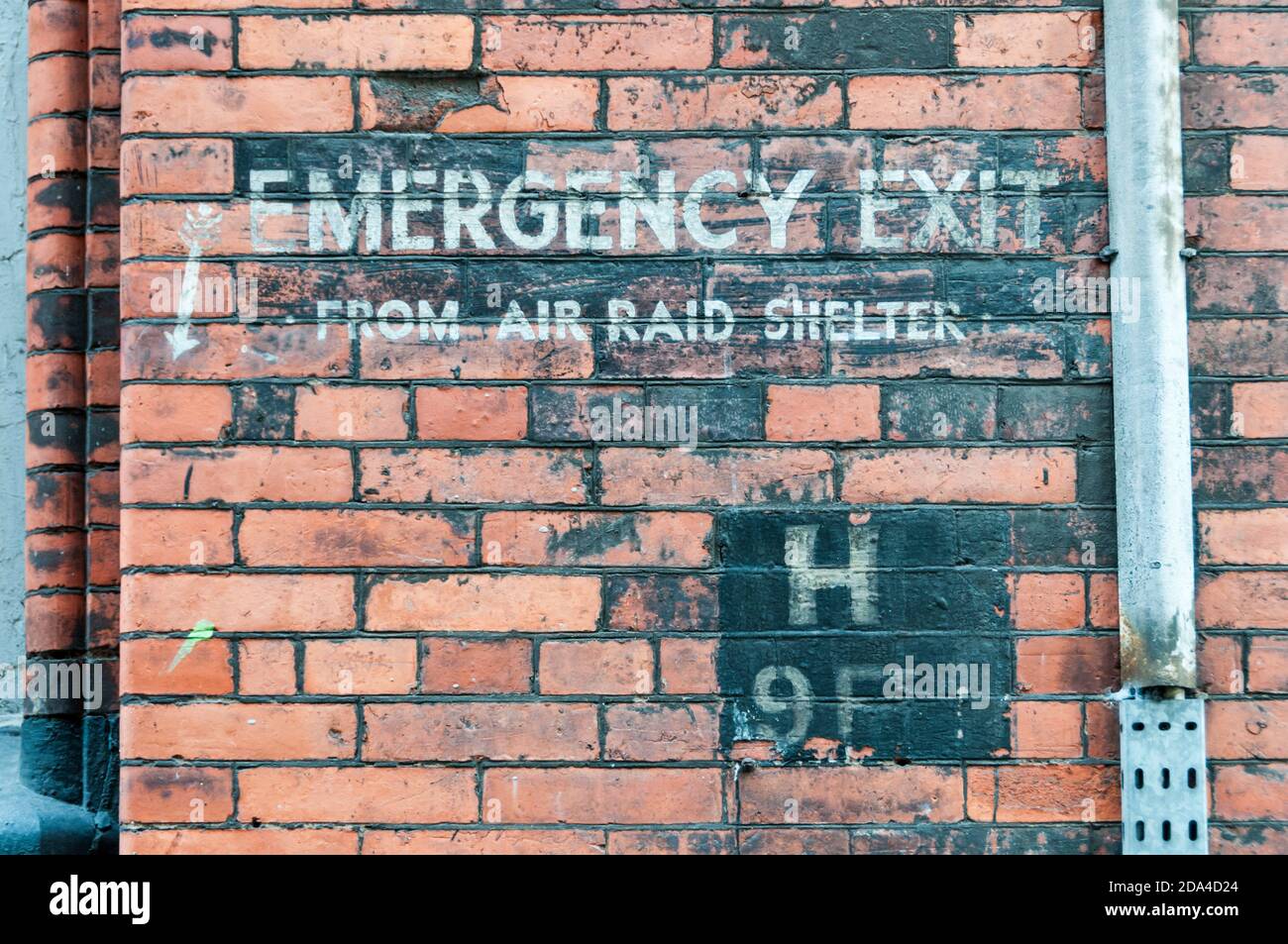 Geisterschild des Zweiten Weltkriegs mit der Aufschrift Notausgang aus Luftschutzkeller am Gebäude in der Eberle Street, Liverpool. Stockfoto