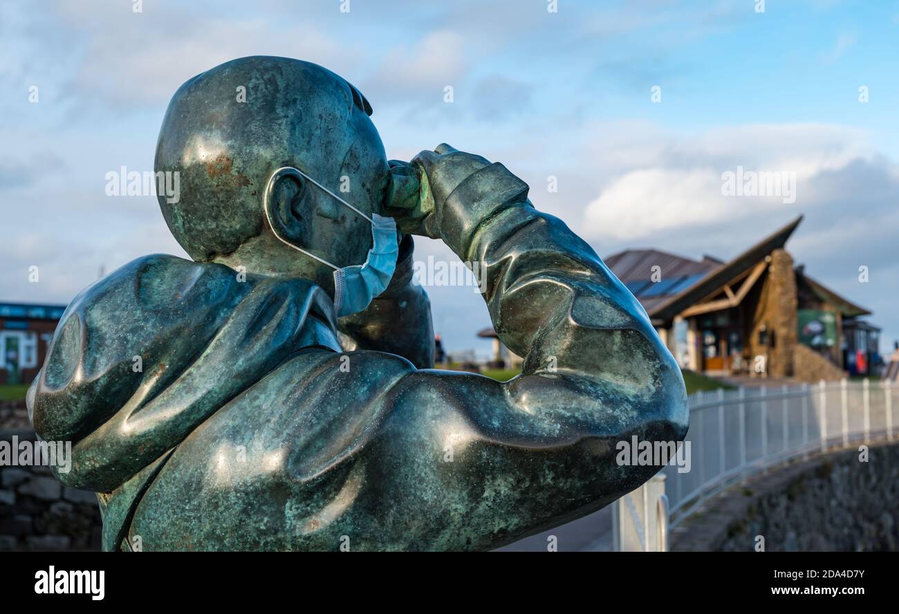 Lebensgroße Bronzeskulptur von Kenny Hunter genannt der Beobachter trägt eine Gesichtsmaske im Scottish Seabird Centre North Berwick, East Lothian, Schottland, Großbritannien Stockfoto