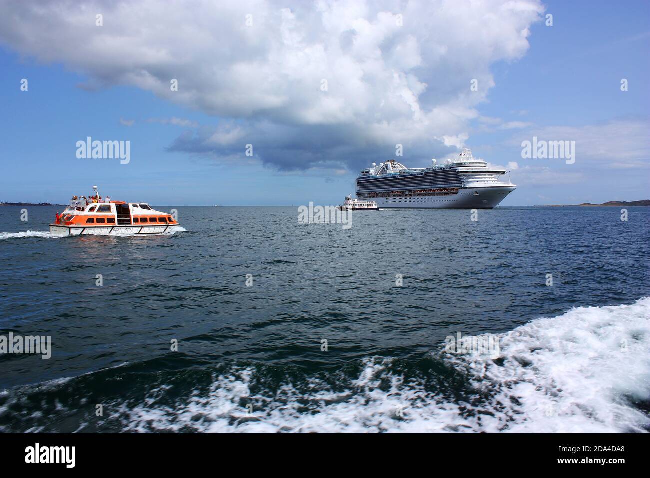 Kanalinseln. Guernsey. Kreuzfahrtschiff Ruby Princess vor Anker mit Schiffen Passagiershuttle und Trident Fähre von Herm. Stockfoto