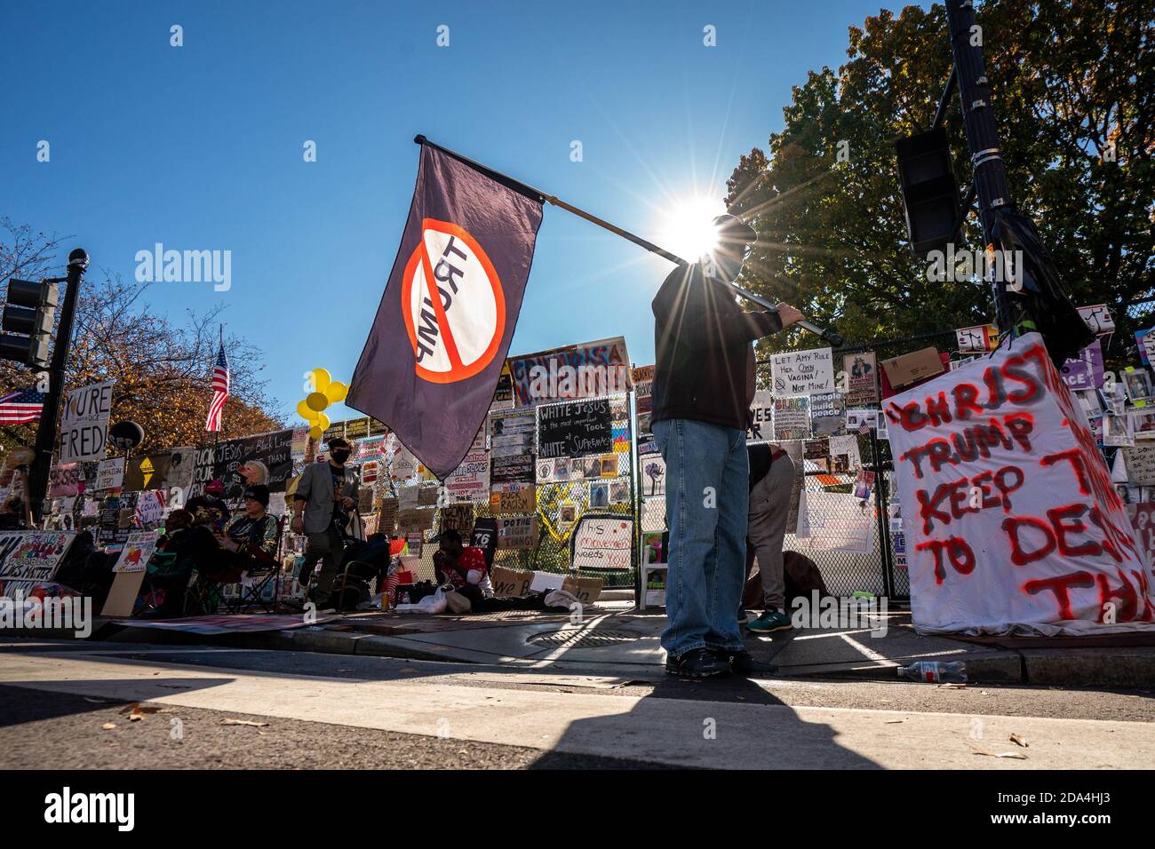 Washington, Usa. November 2020. Am Montag, den 9. November 2020, läuft ein Mann mit der "No Trump"-Flagge entlang des mit einem Schild gefüllten Zauns, der die Grenze zwischen BLM Plaza und Lafayette Park in Washington, DC, säumte. Foto von Ken Cedeno/UPI Kredit: UPI/Alamy Live Nachrichten Stockfoto