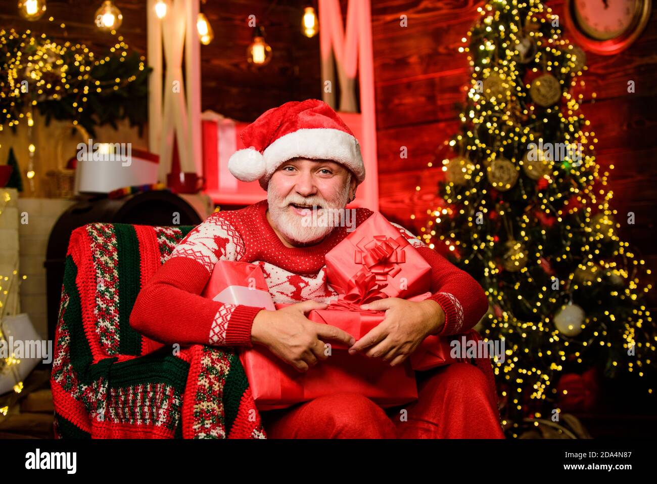 Weihnachtsmann entspannt im Sessel. Geschenke liefern. Winterurlaub. frohe  weihnachten. Älterer Opa zu Hause. Traditions-Konzept. Weihnachtsmann in  der Nähe von weihnachtsbaum. Bärtiger älterer Mann Santa Claus  Stockfotografie - Alamy