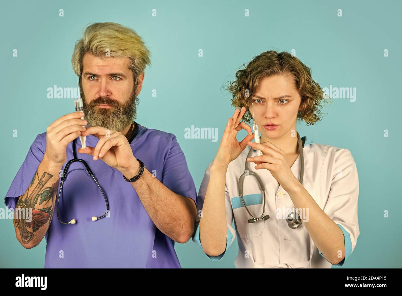 Erfolgreiches Team von Ärzten. Menschen in Uniformen blauer Hintergrund. Medizinisches Personal. Vertrauen Sie unseren Mitarbeitern. Gesundheitswesen. Teamarbeit und Personalkonzept. Arzt und Krankenschwester verwenden Spritze. Stockfoto
