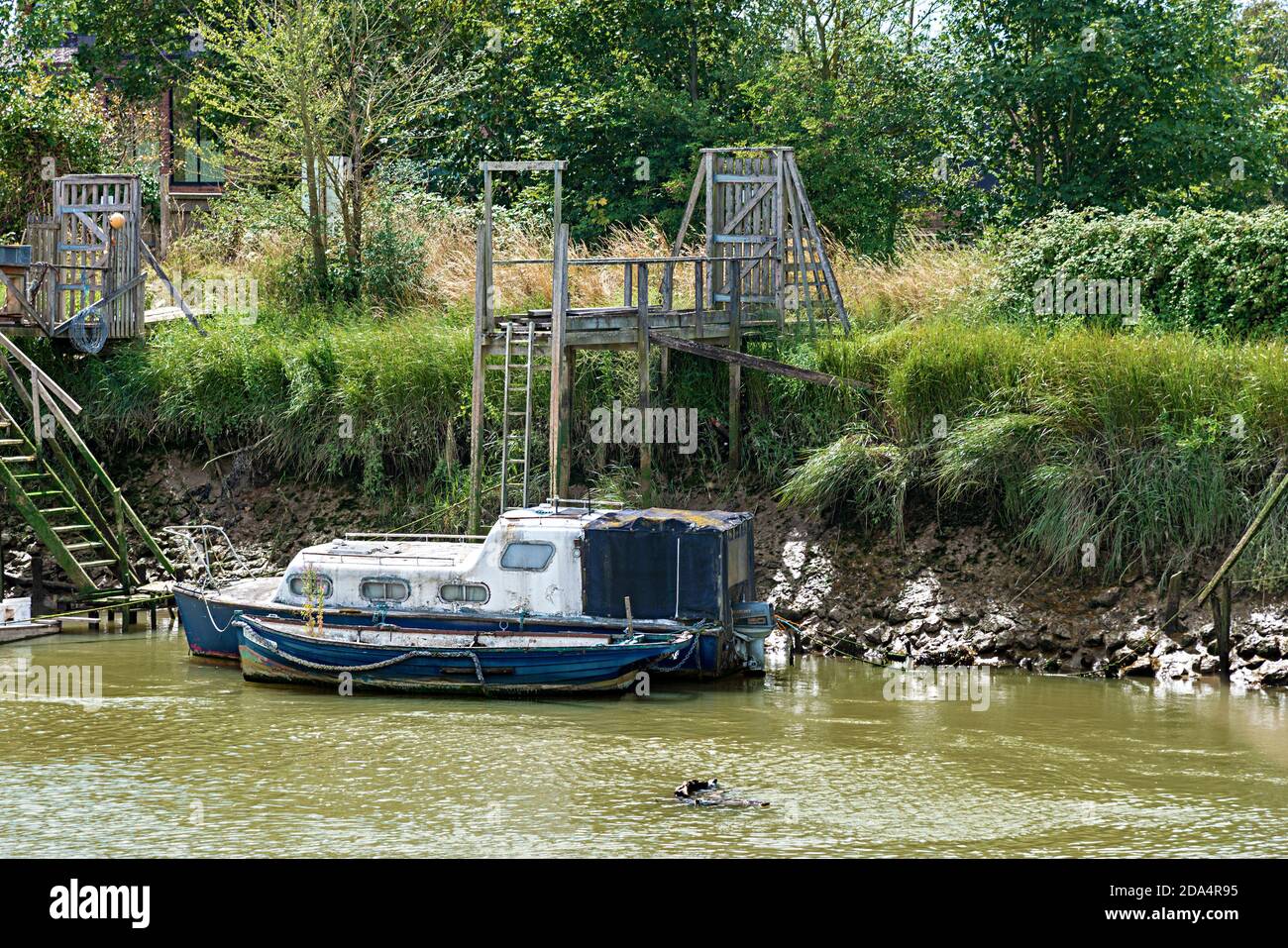 Vernachlässigtes, schmutziges altes Motorboot an einem Liegeplatz am Ufer des Flusses Arun in Arundel, West Sussex, England, Großbritannien Stockfoto