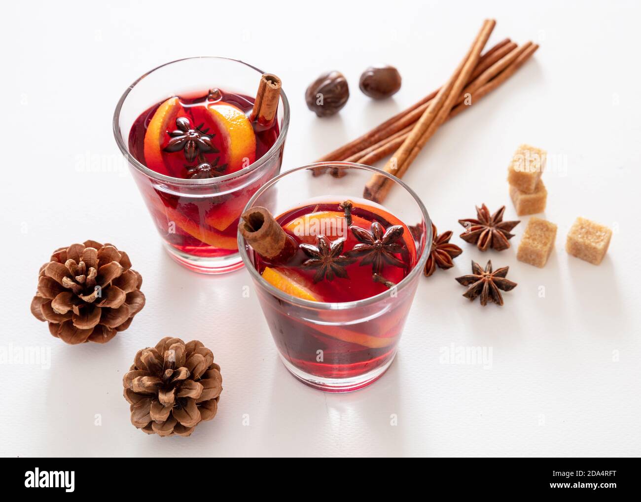 Glühwein, Winter Weihnachten wärmende Alkoholgetränk, zwei Glas Tassen, Zutaten Orange und Gewürze auf weißem Hintergrund, Nahaufnahme. Stockfoto