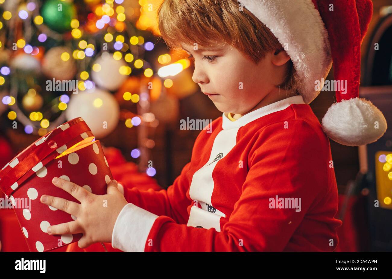 Geschenk-Box. Weihnachtsmann Junge feiern weihnachten zu Hause. Elfenes Kind. Zu Hause. Kindheitsmomente. Urlaub. Innen. Einkaufsverkauf. Es ist ein Wunder. Kind fröhlich Stockfoto