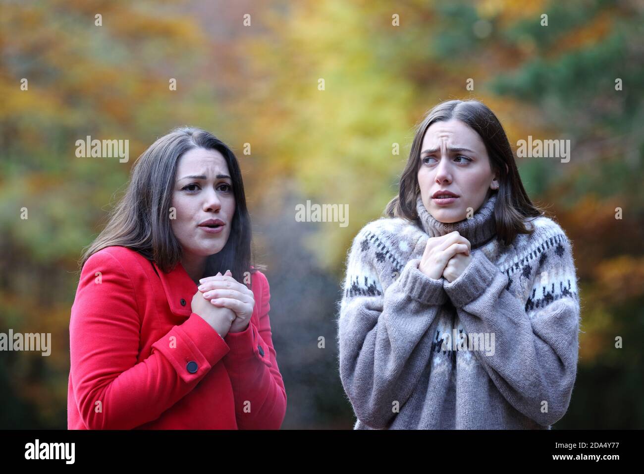 Zwei Frauen beschwerten sich, dass es kalt wurde, als sie in einem Park gingen Herbst Stockfoto