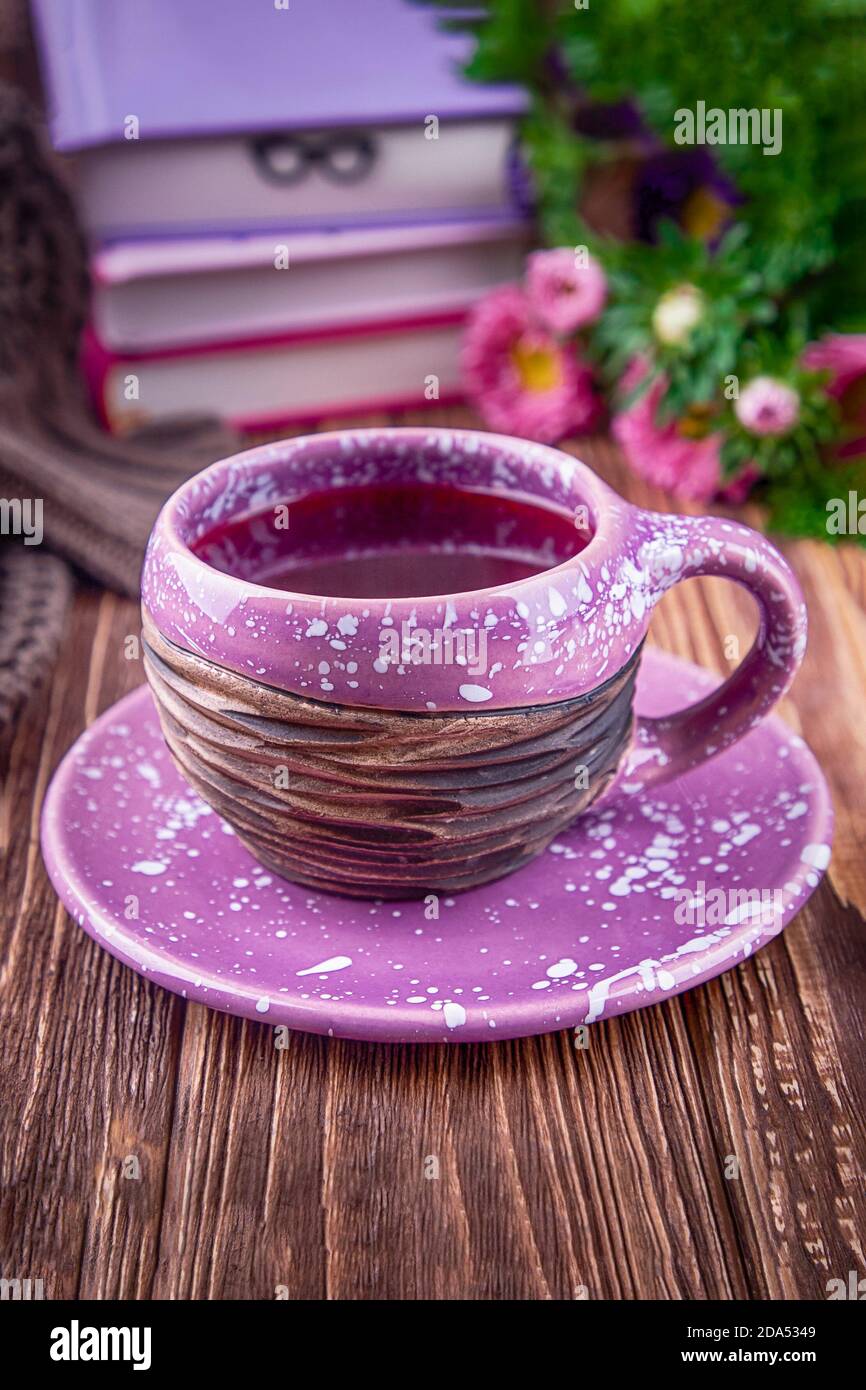 Früchtetee, Bücher und Blumenaster auf Holzhintergrund Stockfoto